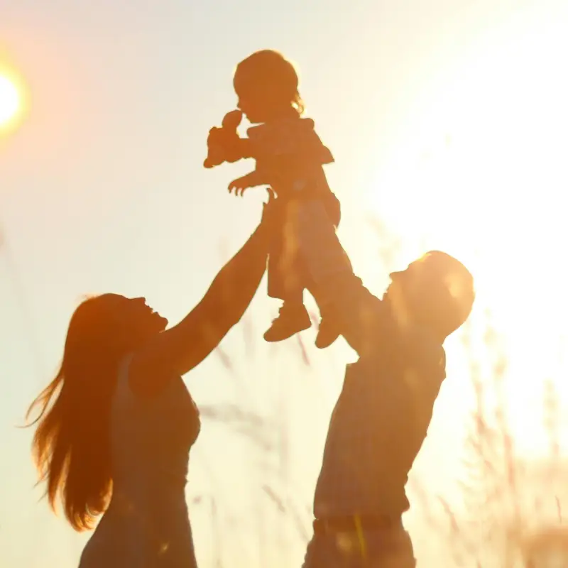 une femme et un homme qui porte un enfant en l'air